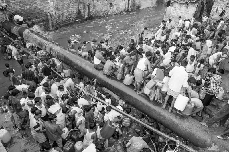 Urban Drinking Water Challenges - Struggling to collect water from a pipeline leakage in South-East district, National Capital Territory of Delhi